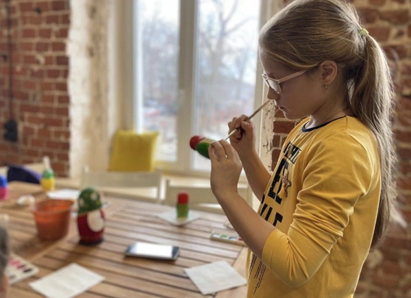 Школьница расписывает матрешку в музее Посадская матрешка